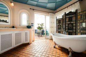 ein großes Badezimmer mit Badewanne und Fenster in der Unterkunft El Refugio Apartments & Villa in La Matanza de Acentejo