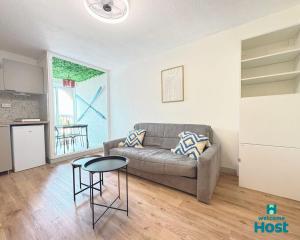 un soggiorno con un divano e un tavolo di Le studio de Lou, 4 couchages Mer & Port a Mauguio