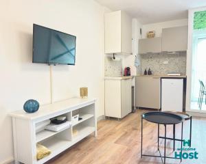 una cucina con tavolo e TV a parete di Le studio de Lou, 4 couchages Mer & Port a Mauguio