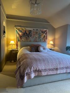 ein Schlafzimmer mit einem Bett, zwei Lampen und einem Kronleuchter in der Unterkunft Flat in Woodstock in Woodstock