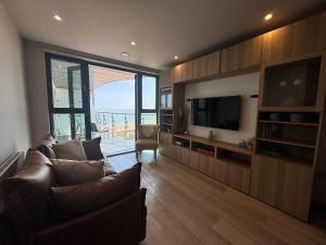 a living room with a couch and a television at Ramsgate Stunning Sea View Apt Free Parking in Kent