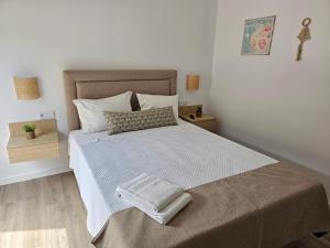 a bedroom with a bed with a towel on it at Curtido House in Aveiro