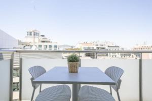 a table with chairs and a potted plant on a balcony at Ola Living Plaza Catalunya in Barcelona +59 photos
