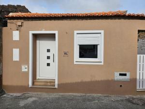 a house with a white door and a window at Curtido House in Aveiro