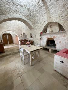 una cucina con tavolo e forno in pietra di Nidadi Trulli d'Itria a Martina Franca Altre 37 foto