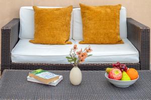 a coffee table with a bowl of fruit and a couch at SARDINIA RE - Libero 22 - Free Parking in Alghero