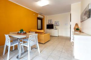 a living room with a table and chairs and a couch at SARDINIA RE - Libero 22 - Free Parking in Alghero +28 photos