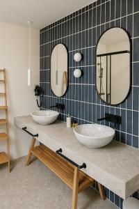 um banheiro com duas pias e dois espelhos em Stone House 4M - Stylish Coastal Stay with 3 Ensuites & Parking, Pag em Pag