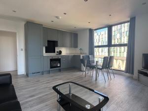 a kitchen and living room with a table and chairs at Alhambra House, Modern 2 Bed Flat - F2 in Croydon
