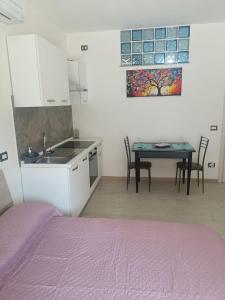 cocina con cama y mesa con sillas en Casale Gabriella Alloggio ergonomico e spazioso, en Capoliveri