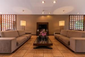 a living room with two couches and a coffee table at Hotel Deville Express Guaira in Guaíra +36 photos