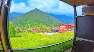 una vista de una montaña desde una ventana en Nil Pansiyon, en Uzungöl