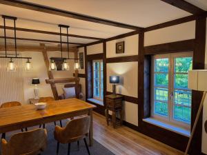 a dining room with a table and chairs and windows at Fewo Luzin 2-5 Pers - Luxus, Steg, Boot in Rothehaus
