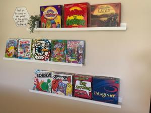 two shelves with games on them on a wall at Dos Brisas by Carolina Mornings in Mars Hill