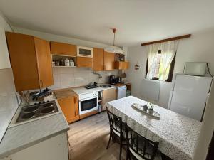 a kitchen with wooden cabinets and a table with chairs at Kod Basaričeka in Donja Stubica