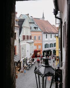 Un grupo de personas caminando por una calle con edificios. en Gall 44 apartments, en Český Krumlov