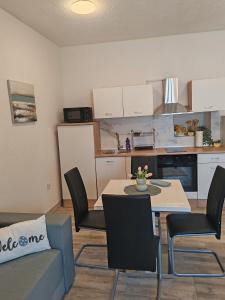 Una cocina y una sala de estar con mesa y sillas. en Apartman Kastel, en Kaštela