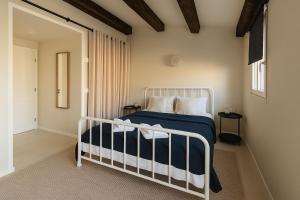 um quarto com uma cama com lençóis azuis e brancos em Stone House 4M - Stylish Coastal Stay with 3 Ensuites & Parking, Pag em Pag