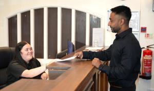 a woman sitting at a desk with a man at a counter at Consort Hotel in Rotherham +18 photos