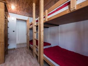 sypialnia z dwoma łóżkami piętrowymi z czerwonymi prześcieradłami w obiekcie Charmant T3 lumineux avec balcon à Tignes Le Lac, proche pistes et commerces - FR-1-502-442 w mieście Tignes +1 zdjęcie