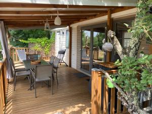 a deck with a table and chairs on it at Le Clos des Capitelles in Saint-Privat-de-Champclos