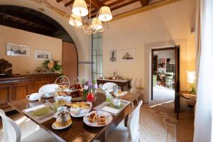 a dining room with a table with food on it at VillAmorosa in Calci