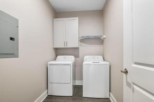 a laundry room with two washing machines and cabinets at Modern 16BR 16BA Condos w Garage and Patio in Wyoming