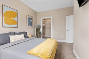 a bedroom with a bed with a yellow blanket on it at Modern 16BR 16BA Condos w Garage and Patio in Wyoming +32 photos
