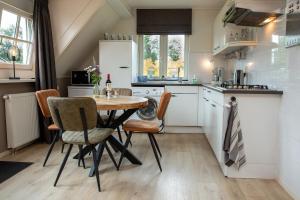 a kitchen with a table and chairs in a room at Appartement Hoornsterzwaag, landelijk gelegen in Hornsterzwaag