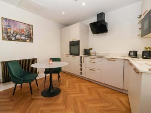 a kitchen with a table and chairs in a room at Baker's Cottage in Beverley