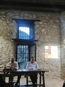 two men sitting at a table in front of a stone wall at #3MTSOPRAILCIELO '' SCuLPTuRe '' in Felitto +200 photos