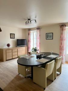 a dining room with a black table and chairs at La Maison Saint-Martin in Agonac