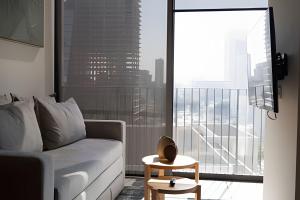 a living room with a couch and a large window at Sao Paulo Vertical in Guadalajara