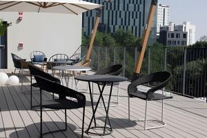 a patio with tables and chairs and an umbrella at Sao Paulo Vertical in Guadalajara