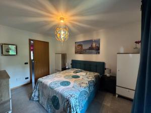 a bedroom with a bed and a chandelier at Casabianca Resort Villas in Lignano Sabbiadoro