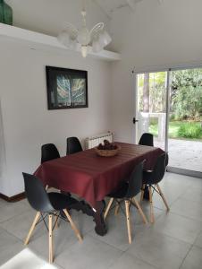 a dining room table with chairs and a ceiling fan at Guindo Cariló in Carilo