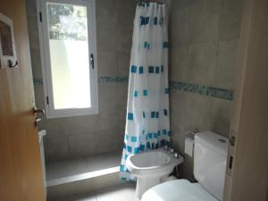 a bathroom with a toilet and a shower curtain at Guindo Cariló in Carilo +18 photos