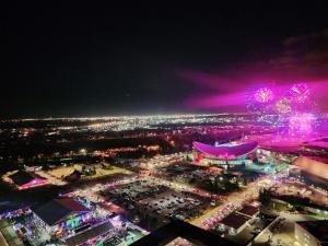 an aerial view of a city at night with fireworks at Stunning Rocky Mountain & DT Skyline Views! Near Stampede, Saddledome, BMO Centre! FREE Banff Pass, Wine, & Parking! in Calgary