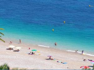 a group of people on a beach with the ocean at Appartement 8 personnes, vue mer, Wi-Fi illimité - FR-1-827-29 in Roquebrune-Cap-Martin