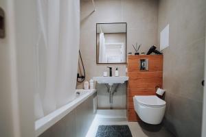 a bathroom with a white toilet and a sink at Central 1BR Near Piața Centrală & Bus Station in Chişinău +43 photos