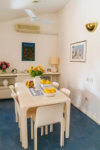 a kitchen and dining room with a table and chairs at Casa a Calaverde pochi passi dal mare terrazza aria condizionata WiFi e parcheggio in Forte Village