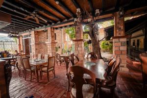 a restaurant with tables and chairs on a patio at Hotel Plaza Menor in Santa Fe de Antioquia