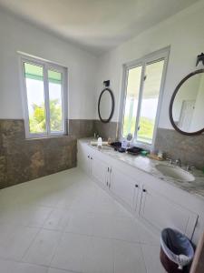 un bagno con lavandino e specchio di Large Beautiful Villa with Ocean Views and private pool - 3 Bedroom Listing a Cap Estate