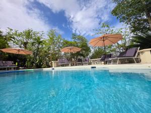 una grande piscina con sedie e ombrelloni di Large Beautiful Villa with Ocean Views and private pool - 3 Bedroom Listing a Cap Estate