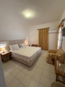 a bedroom with a large white bed and a window at Asteri Hotel in Livadi