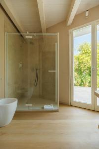 a bathroom with a tub and a glass shower at Portonovo Suites - Riviera del Conero in Ancona