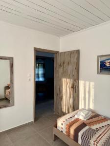 a bedroom with a bed and a wooden door at Villa Dimitris in Ormos Panagias