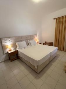 a bedroom with a large bed and two lamps on tables at Asteri Hotel in Livadi