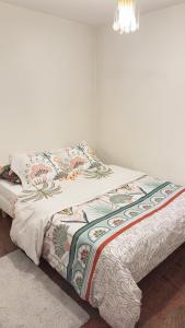 un letto con una coperta sopra di Appartement 4 personnes Drancy a Drancy