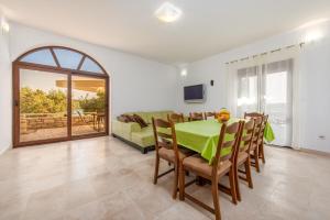 een eetkamer met een groene tafel en stoelen bij Villa On The Beach in Pirovac